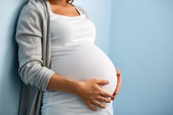 Schwangere, die sich den Bauch hält